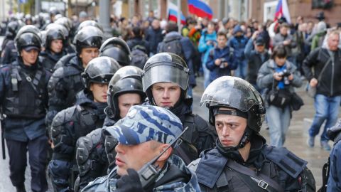 Riot police follow protesters in Moscow on Saturday.