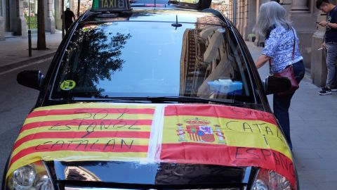 A car is adorned with Spanish and Catalan flags reading "I am Spanish and Catalan" and "I am Catalan and Spanish."