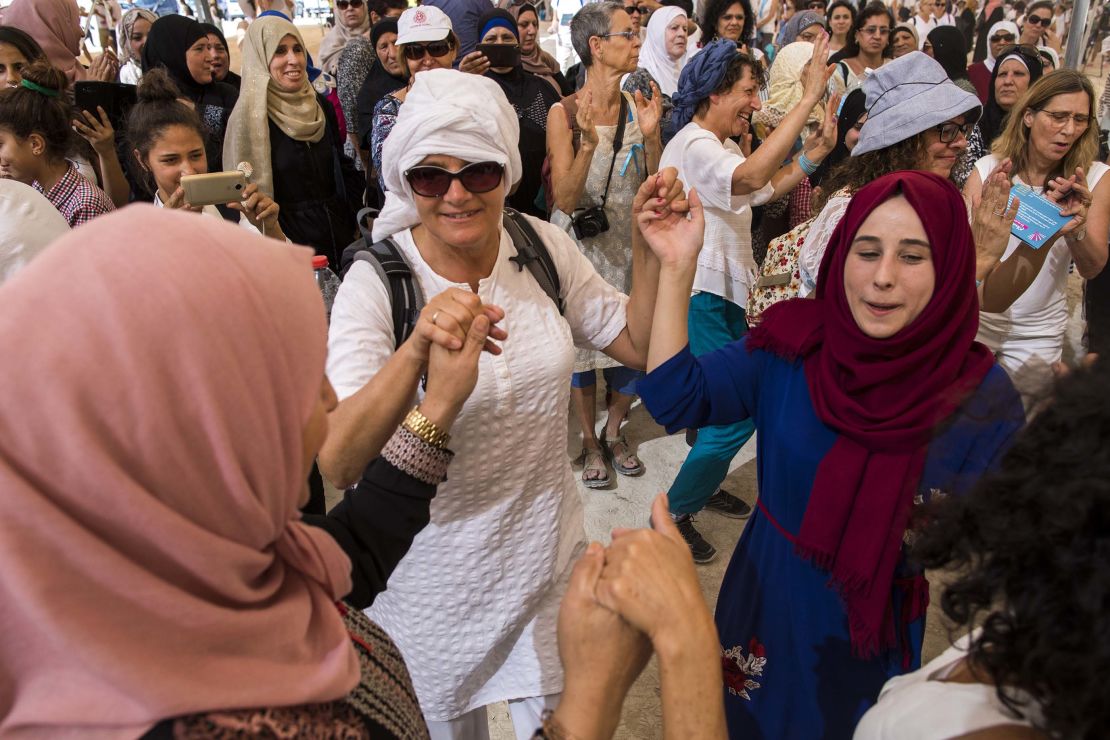 Israeli and Palestinian women dance together under a large tent during the mass protest.