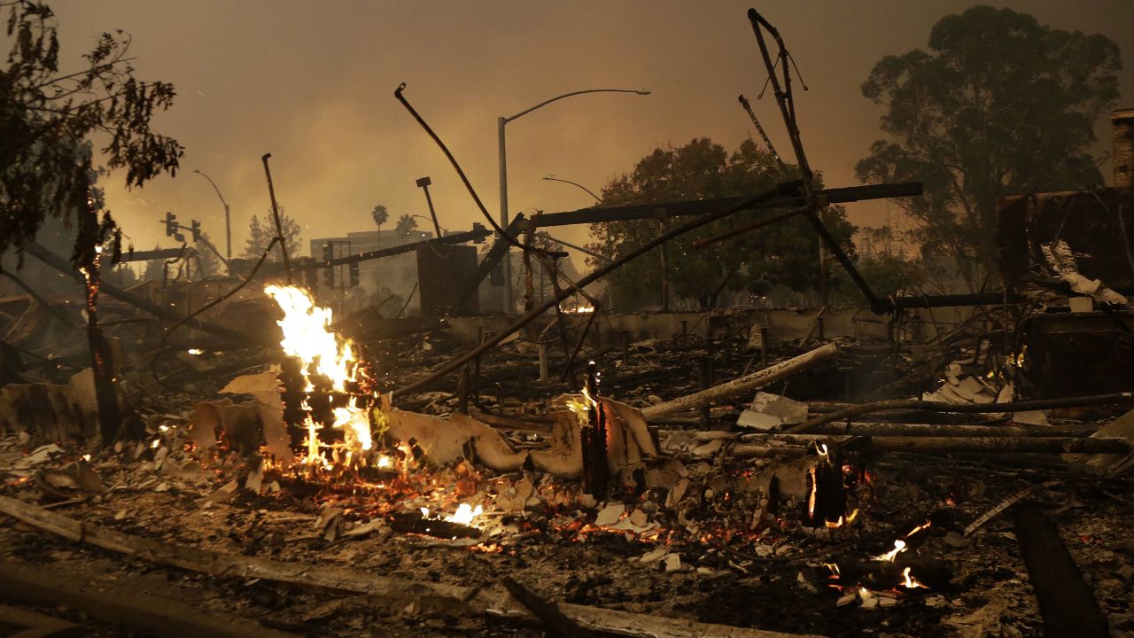 Flames rise from the remains of a burned commercial building in Santa Rosa, California, on Monday.