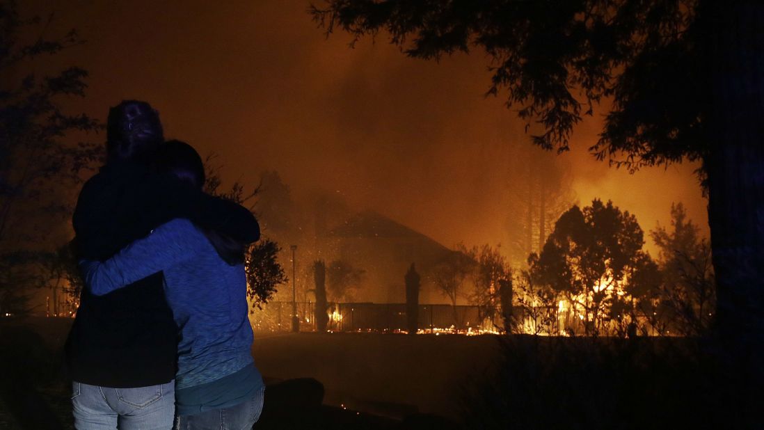 Two women hug as they watch houses burn in Santa Rosa on October 9.