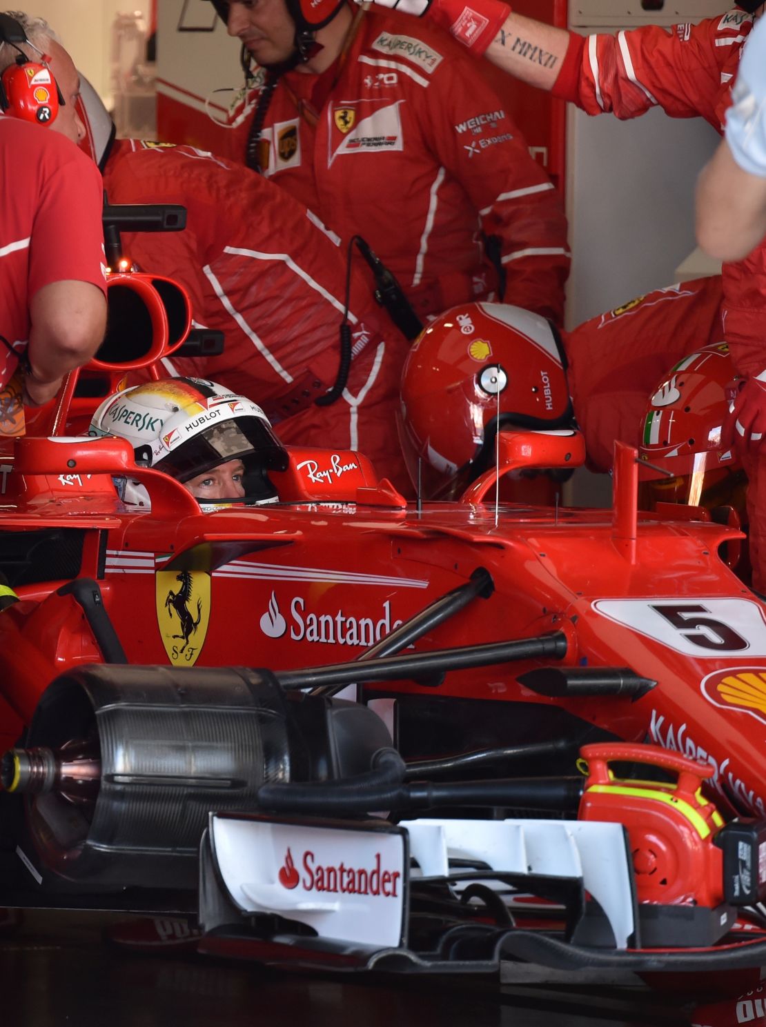 End of the road? Vettel is surrounded by Ferrari mechanics in the pit garage at Suzuka.