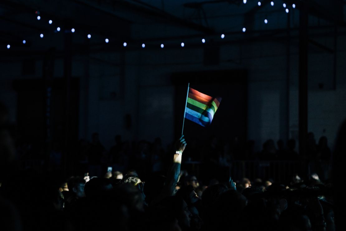 A fan waves a rainbow flag during Betty Who's performance at the "All Things Go Fall Classic" music festival at Union Market in Washington, DC on Oct. 8, 2017