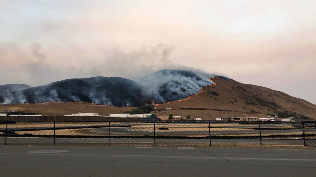 A wildfire burns behind the Sonoma Raceway on October 9.