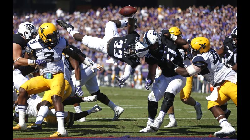 TCU running back Sewo Olonilua, center, dives over the goal line to score a touchdown against West Virginia on Saturday, October 7, in Fort Worth, Texas. TCU defeated West Virginia 31-24.