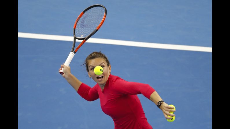 Simona Halep of Romania eyes a ball to hit to the spectators after defeating Maria Sharapova in their women's singles match of the China Open tennis tournament in Beijing on Wednesday, October 4.