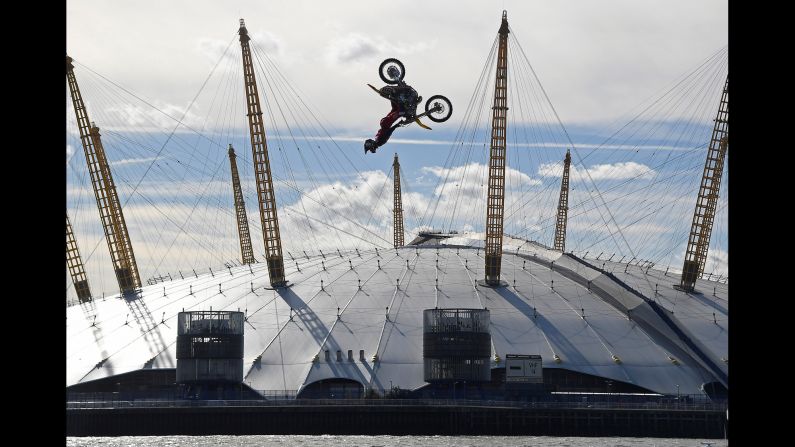 Action sports performer Travis Pastrana somersaults on his motorbike as he jumps between two barges on the River Thames in London, on Thursday, October 5.