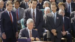 Stephen Sposato, whose wife was killed when a gunman invaded the San Francisco law firm where she worked, left, and Marc Klass, whose daughter was kidnapped and killed, right, look on after President Bill Clinton signed the $30 billion crime bill on the South Lawn of the White House in Washington on Sept. 13, 1994. Rep. Patricia Schroeder, D-Colo., and House Speaker Thomas Foley of Washington also look on. (AP Photo/Dennis Cook)