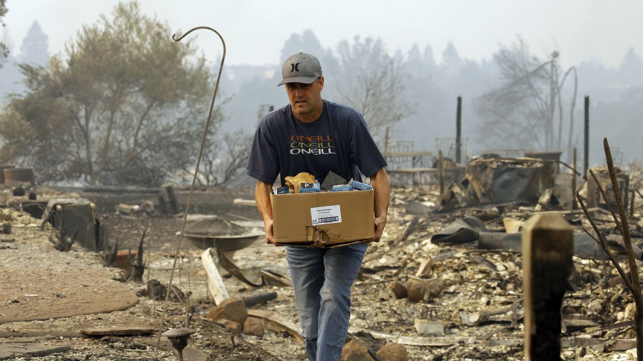 A man retrieves belongings from  where his house once stood in the Fountaingrove area of Santa Rosa.