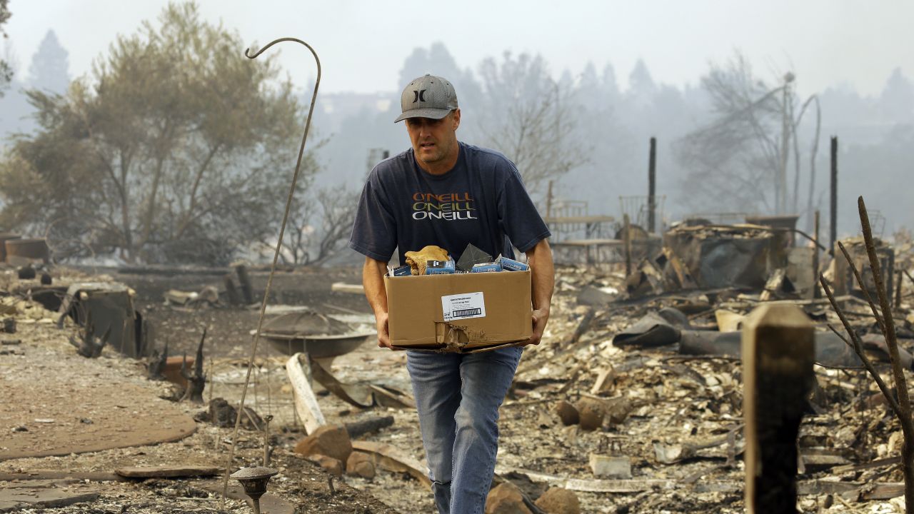 A man retrieves belongings from where his house once stood in the Fountaingrove area of Santa Rosa.
