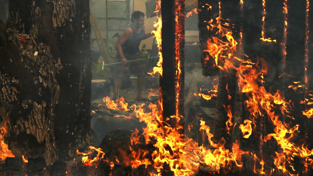 A man rushes to save his house as a wildfire moves through Glen Ellen on October 9.