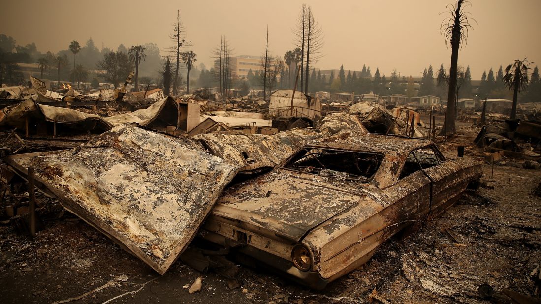 The remains of fire-damaged homes and cars smolder at a Santa Rosa trailer park on October 9.