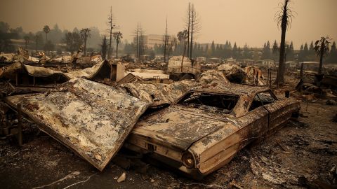 The remains of fire-damaged homes and cars smolder at the Journey's End Mobile Home Park in Santa Rosa, California, on October 9.