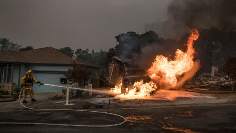 A firefighter douses flames in Santa Rosa on October 9. 