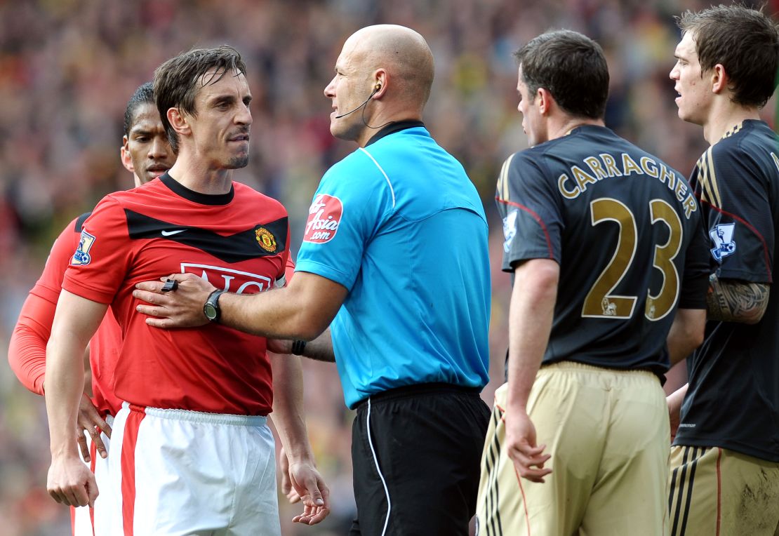 Referee Howard Webb holds United's Gary Neville away from Liverpool's defender Jamie Carragher during a United v Liverpool match at Old Trafford.