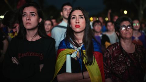 Pro-independence supporters react as they watch on broadcast screens outside the Parliament of Catalunya as the Catalan President Carles Puigdemont announces he will abide by the referendum results on October 10, 2017 in Barcelona, Spain. 