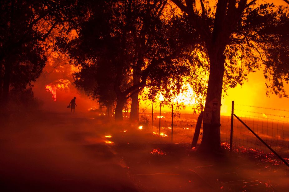 A TV cameraman inches closer to a burning building at a winery in Napa Valley on Monday, October 9. 