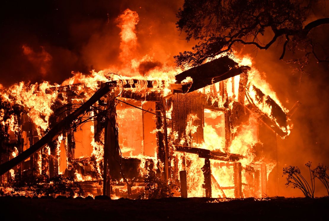 Flames ravage a home in California's Napa wine region as multiple wind-driven fires continue whipping the region. 