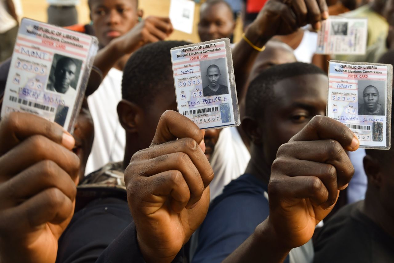 Voters in Monrovia, Liberia, hold their voting card prior to casting their vote for Liberia's presidential and legislative elections, at a polling station on October 10, 2017. It will be the first time since 1944 that one democratically-elected government will transition to another.