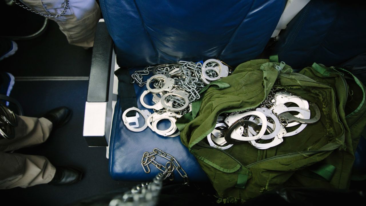 As the flight nears Guatemala City, guards remove detainees' shackles and handcuffs.