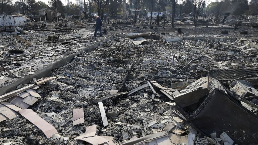 Phil Rush walks through the burnt remains at the site of his home destroyed by fires in Santa Rosa, Calif., Wednesday, Oct. 11, 2017. Wildfires tearing through California's wine country continued to expand Wednesday, destroying hundreds more homes and structures and prompting new evacuation orders. 