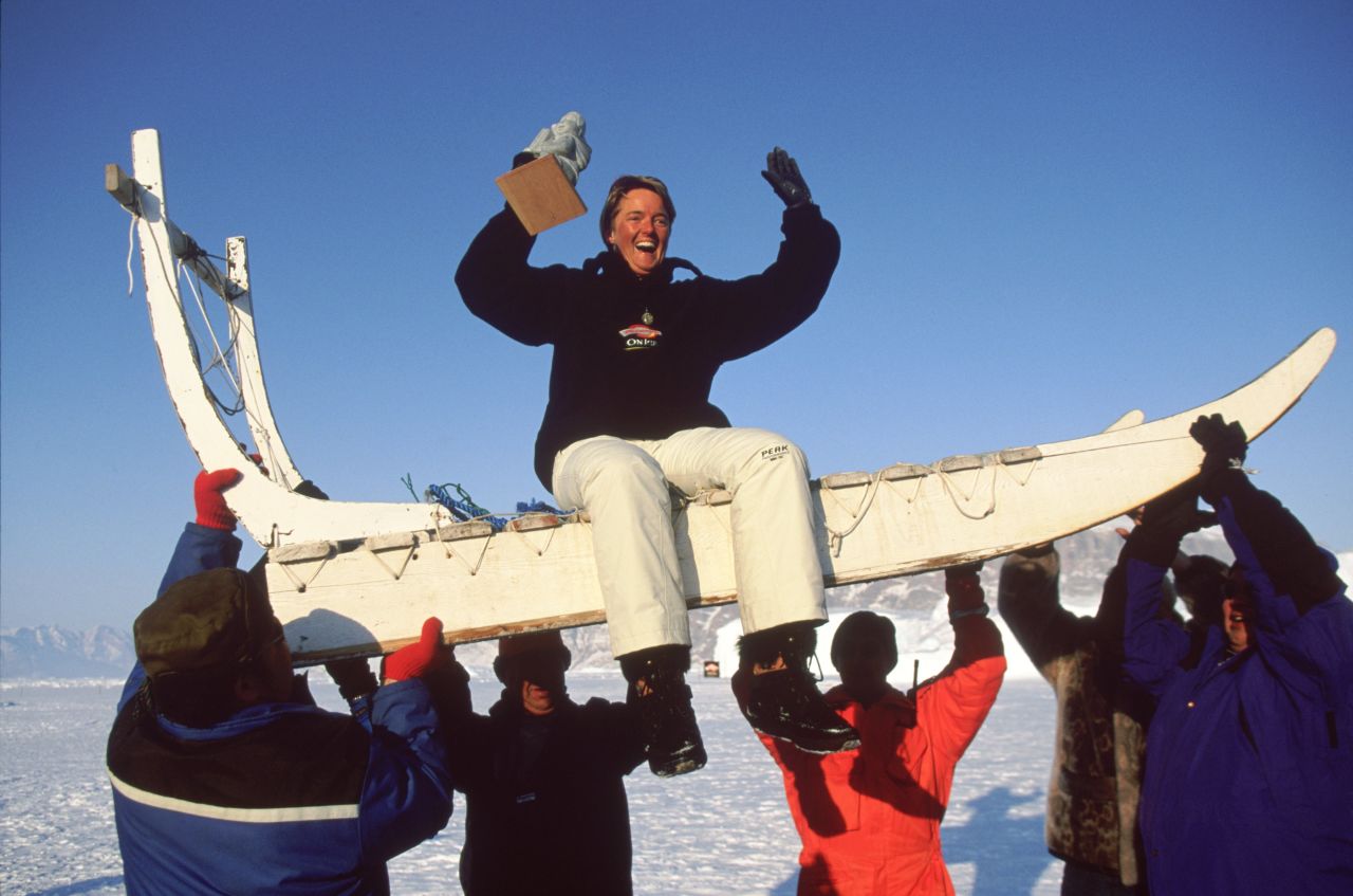 A winner is lifted atop a traditional dog sled after victory...