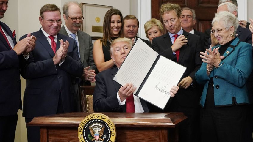 US President Donald Trump shows an executive order which he just signed on health insurance on October 12, 2017 in the Roosevelt Room of the White House in Washington, DC. / AFP PHOTO / MANDEL NGAN        (Photo credit should read MANDEL NGAN/AFP/Getty Images)