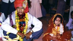 A 16 year old boy (L) waits to be married to a much younger girl (R) during a mass child marriage ceremony in Indore, 15 May 2002.