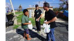 Dr. Humberto Guzman checks on a woman in the Del Negro neighborhood of Yabucoa as a volunteer delivers her food and water.