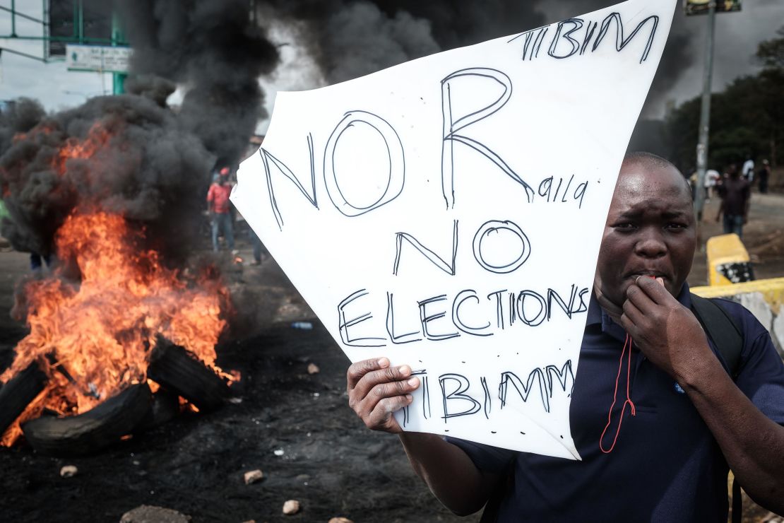 An opposition supporter stands near a pile of burning tires during a protest in Kisumu on Wednesday.