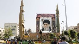 Iranians walk past Sejjil (L) and Qadr-H medium range ballistic missiles displayed next to a portrait of Iranian Supreme Leader Ayatollah Ali Khamenei on the occasion of the annual defence week which marks the anniversary of the 1980s Iran-Iraq war, on September 25, 2017, on Baharestan square in Tehran. (ATTA KENARE/AFP/Getty Images)