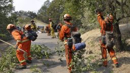 Prisoners from the McCain inmate crew from San Diego, Calif., clear brush from a road on Wednesday, Oct. 11, 2017 in Calistoga, Calif. The wildfires tearing through California wine country flared anew Wednesday, growing in size and number as authorities issued new evacuation orders and announced that hundreds more homes and businesses had been lost. (AP Photo/Ben Margot)