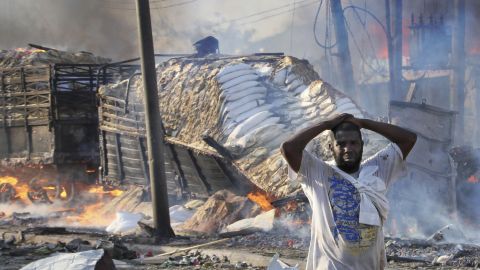 A Somali man reacts after seeing a body and destroyed buildings.