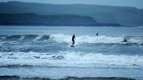 A woman surfs on Lahinch Strand in County Clare, Ireland, on October 15, 2017 -- the eve of Ophelia's arrival.