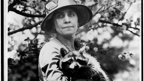 First Lady Grace Coolidge is seen holding her pet raccoon, Rebecca.