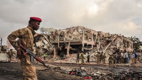 Somali soldiers patrol the scene of the explosions in the center of Mogadishu.