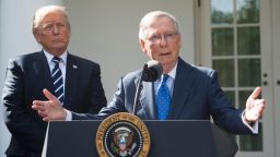 US President Donald Trump listens to Senate Majority Leader Mitch McConnell (R), Republican of Kentucky, speak to the media in the Rose Garden of the White House in Washington, DC, October 16, 2017.