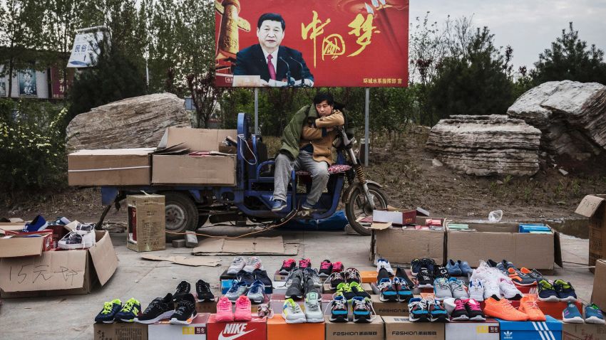 SHIJIAZHUANG, CHINA - APRIL 9: A Chinese vendor sells sneakers and shoes in the street in front of a sign showing Chinese President Xi Jinping with "China Dream" written on it, on April 9, 2017 in Shijiazhuang, Hebei province, China. China's economy grew 6.9 percent in the first quarter of 2017, a government report said on April 17, 2017, which was higher then expected and another signal that the world's second largest economy could be stabilizing. (Photo by Kevin Frayer/Getty Images)