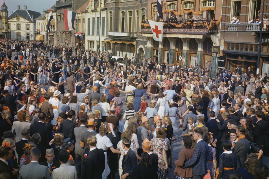 Dutch civilians dance in the streets after the liberation of Eindhoven by Allied forces, September 1944.<br />"The great thing about this particular scene is the orange: when the Dutch were liberated they hung out flags and sheets, everything was orange and that would be lost in a black and white photograph," said Carter.