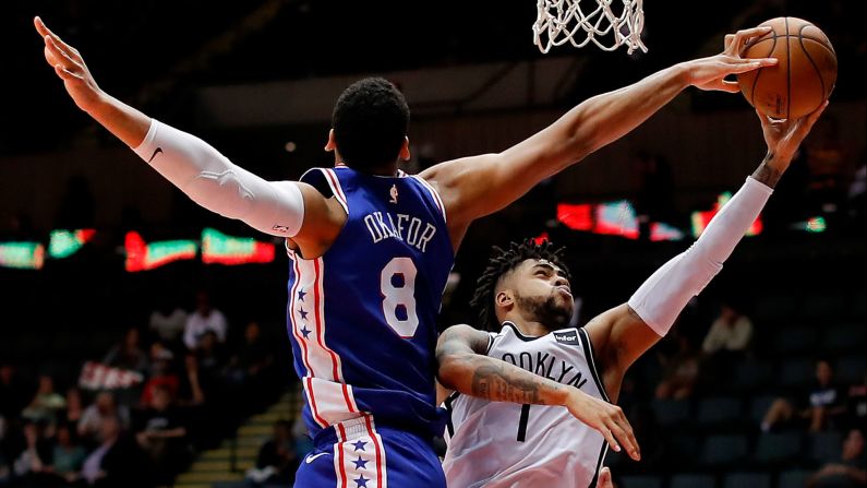 Brooklyn Nets guard D'Angelo Russell shoots as Philadelphia 76ers center Jahlil Okafor gets his fingers on the ball during the fourth quarter of a preseason NBA basketball game on Wednesday, October 11, in Uniondale, New York.