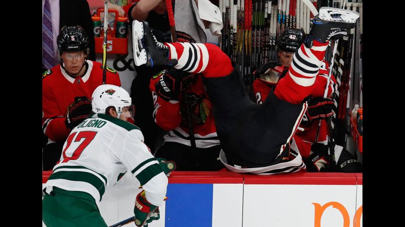 Chicago Blackhawks' Brent Seabrook, right, goes over the boards after missing a check on Minnesota Wild's Marcus Foligno during the first period of an NHL hockey game on Thursday, October 12, in Chicago.