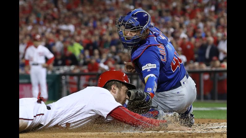 Willson Contreras of the Chicago Cubs tags out Trea Turner of the Washington Nationals at the plate during the first inning in Game Five of the National League Division Series at Nationals Park on Thursday, October 12, in Washington.