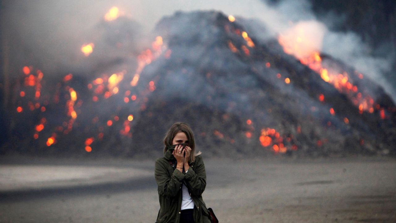 A woman in Galicia, Spain, covers her face to protect herself from the smoke.