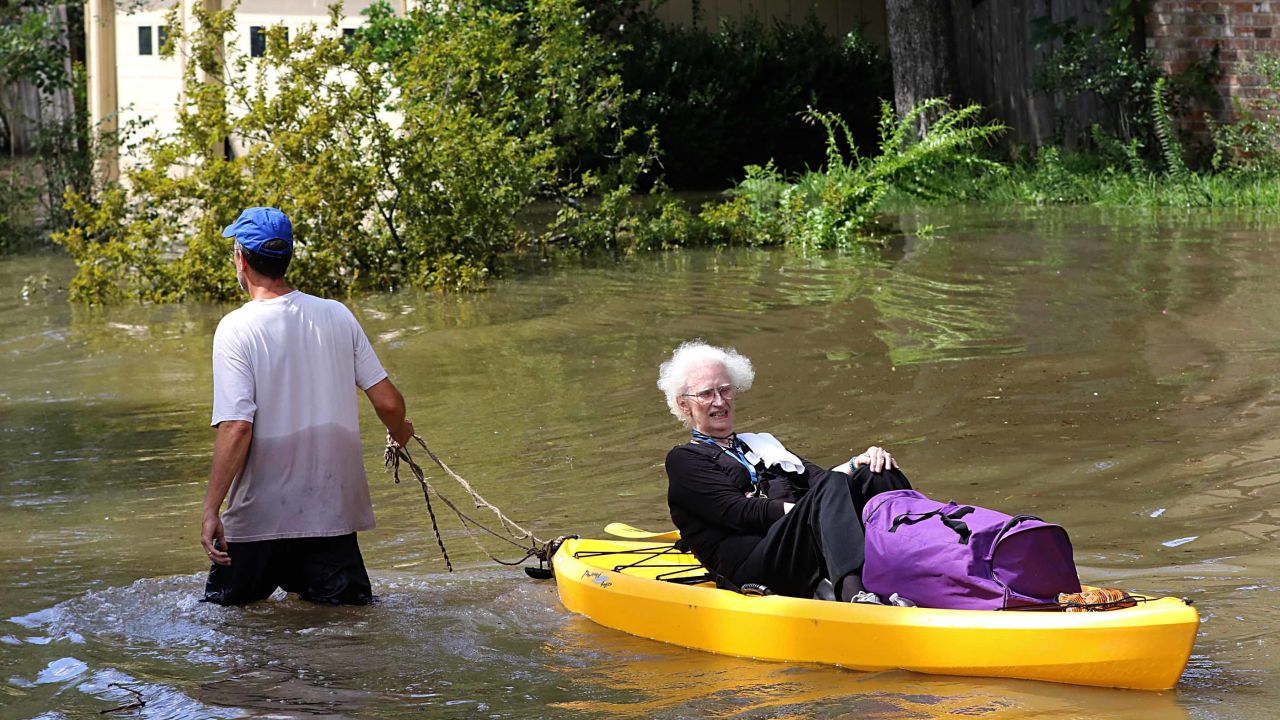 A woman is evacuated by canoe in Houston after Hurricane Harvey dumped record rainfall in 2017.