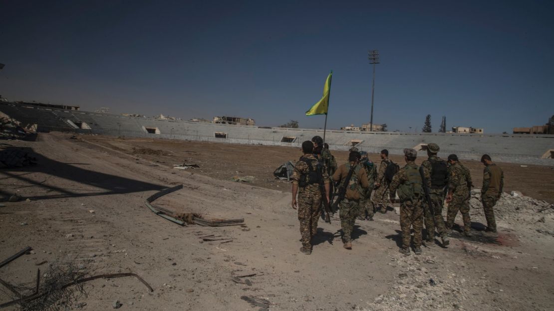 Soldiers of SDF reaching inside of stadium to put the flag.
Syria, Raqqah - October 17, 2017