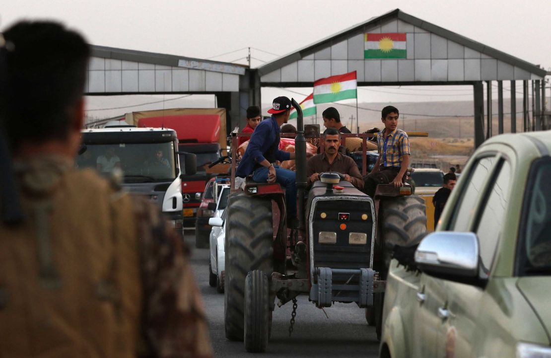 Families cross a checkpoint Monday in Altun Kupri, Iraq, as they flee violence in northern Kirkuk.