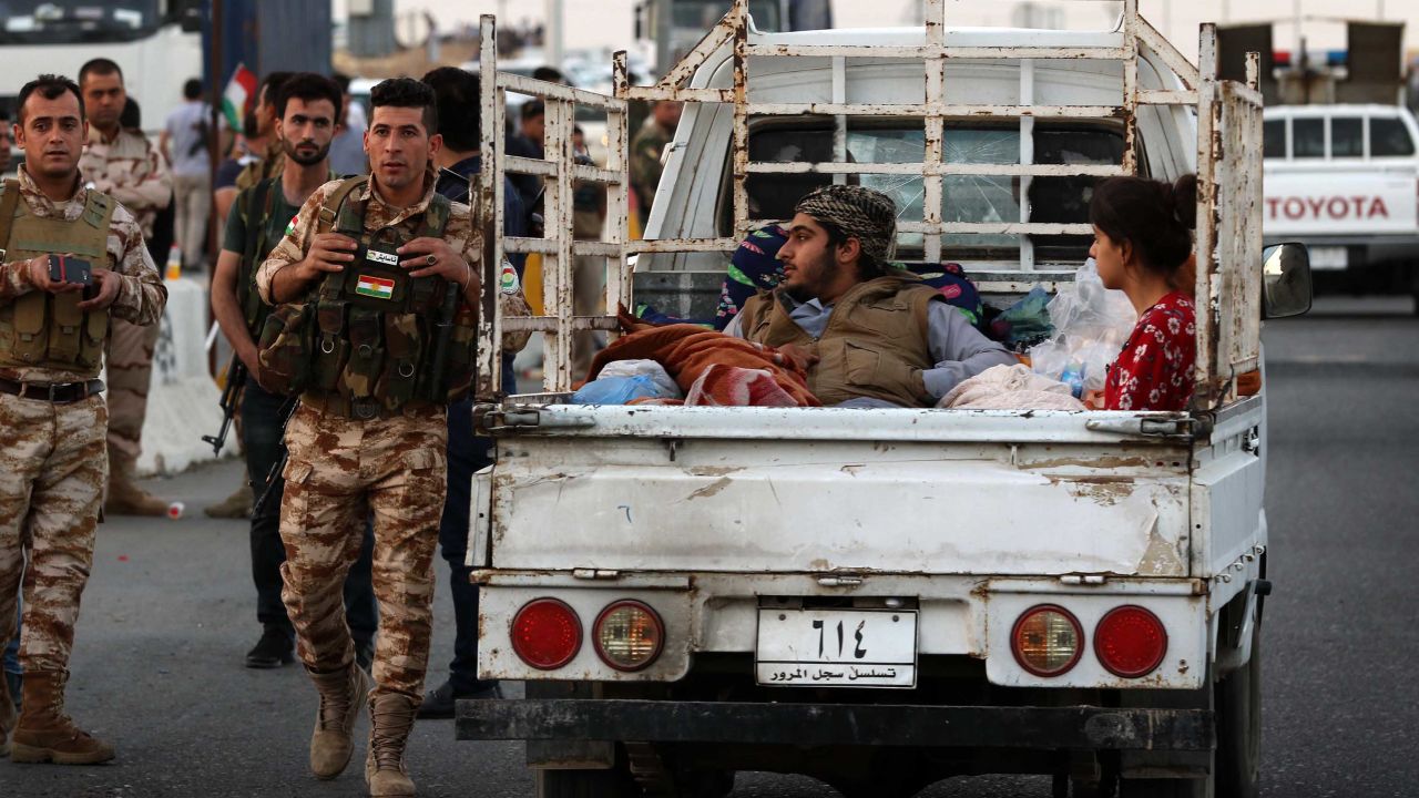 Kirkuk residents cross a Kurdish checkpoint in Altun Kupri on Monday.