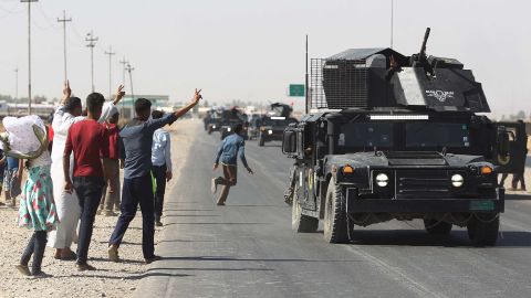 Locals wave to Iraqi forces as they arrive in southern Kirkuk on Monday.