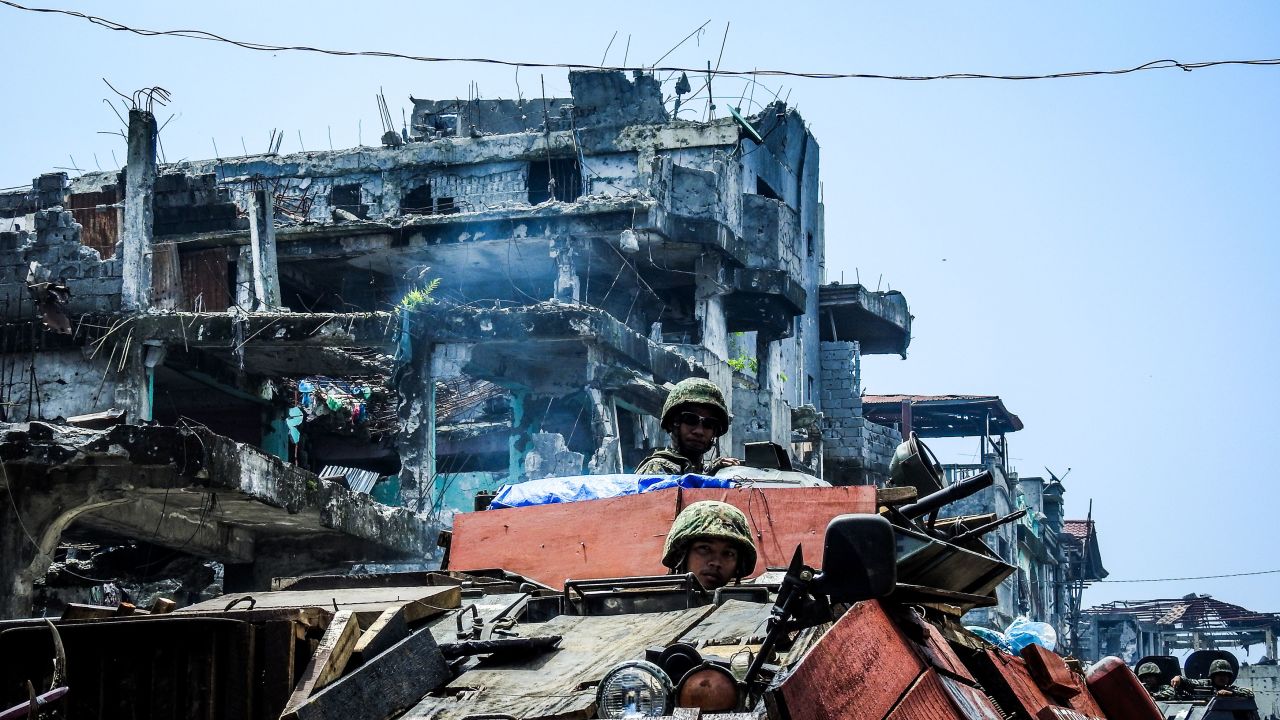 Philippine soldiers move past damaged buildings in Marawi on August 30, 2017, as fighting between government troops and pro-Islamic state militants entered its 100th day.