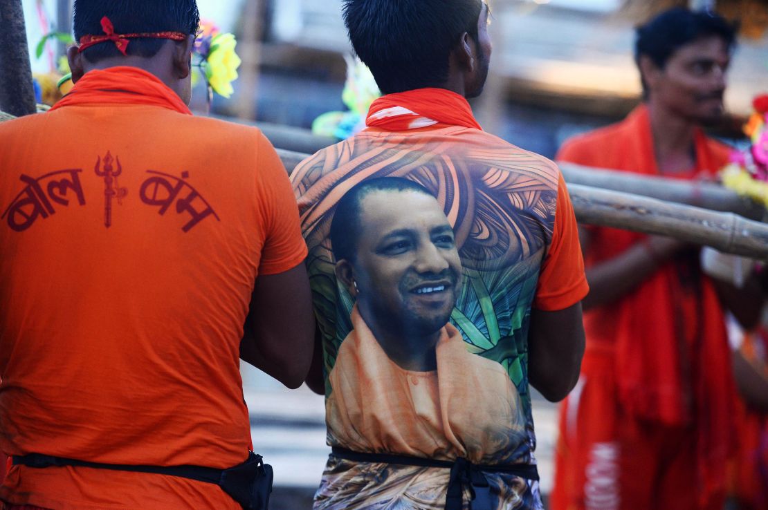 A Hindu devotee, wearing a t-shirt with a photo of Uttar Pradesh Chief Minister Yogi Adityanath, stands on the bank of Ganges, July 14, 2017. 